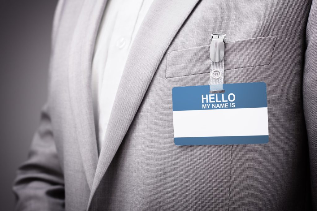 Businessman wearing Hello my name is tag